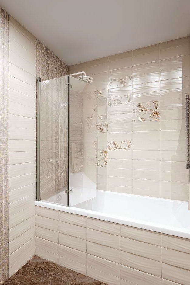 Дизайн интерьера совмещенной ванной комнаты со стиральной машиной, в бежевом цвете с вставками из мозаики и рельефной плиткой, вид на ванну 