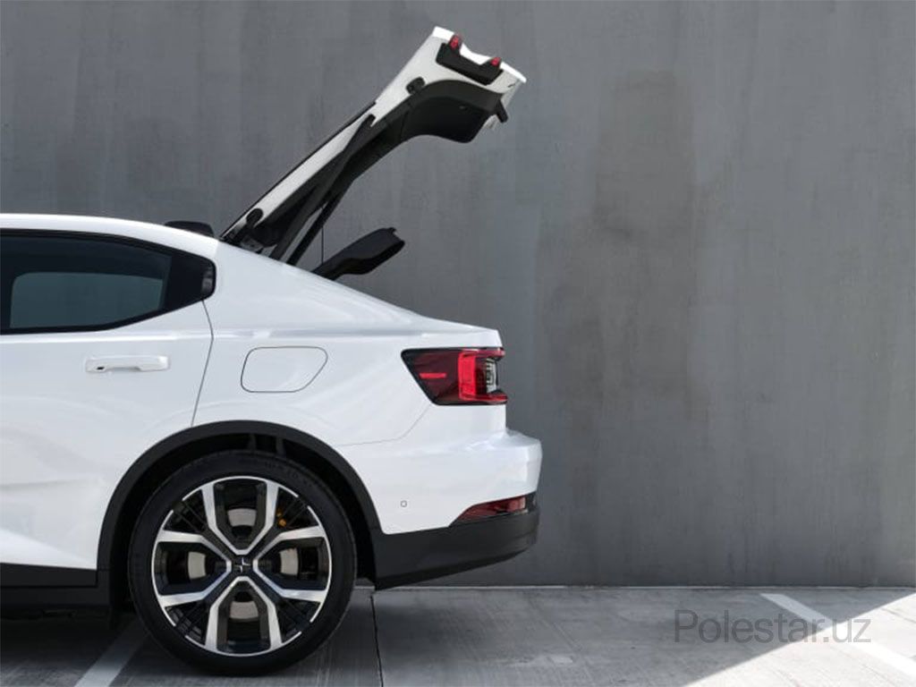 Белый Polestar 2 сверху, припаркованный рядом с белым зданием